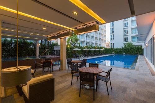 un patio extérieur avec des tables et des chaises ainsi qu'une piscine dans l'établissement Kantary 304 Hotel Prachinburi, à Si Maha Phot