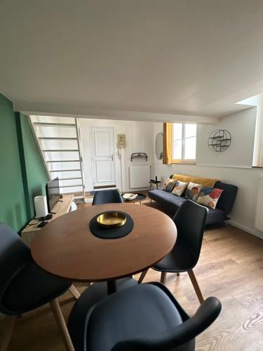 un salon avec une table, des chaises et un canapé dans l'établissement Charmant Duplex Rouen Centre, à Rouen
