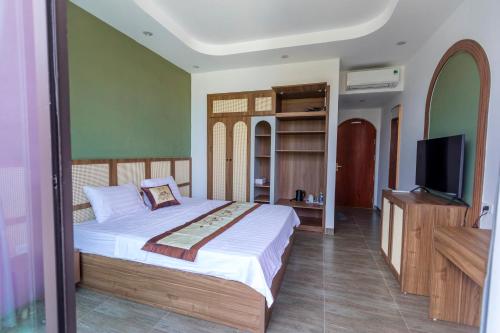 a bedroom with a bed and a flat screen tv at Villa A506 Hải Tiến, Thanh Hóa với 5 phòng ngủ tiện nghi in Thanh Hóa
