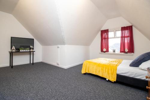 a bedroom with a bed and a tv at Pebbles guest house quad room 10 in Southampton