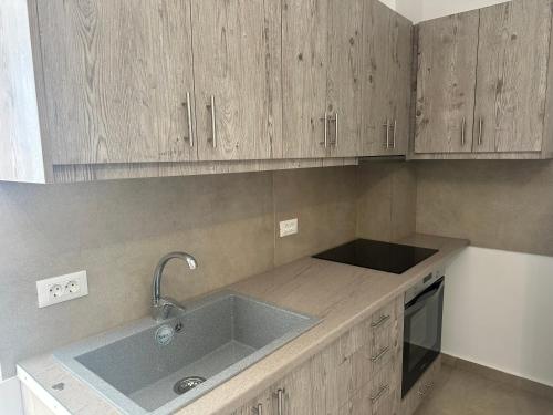 a kitchen with a sink and wooden cabinets at Amuse Mykonos Boutique Hotel in Mýkonos City