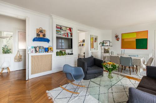 un salon avec des chaises et une table dans l'établissement Faidherbe-Superbe duplex proche Bastille, à Paris