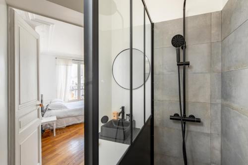 La salle de bains est pourvue d'une douche et d'un miroir. dans l'établissement Faidherbe-Superbe duplex proche Bastille, à Paris