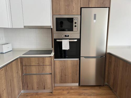 a kitchen with a refrigerator and a microwave at Janelas da Praça in Miranda do Corvo