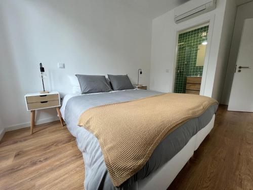 a bedroom with a large bed and a window at Janelas da Praça in Miranda do Corvo