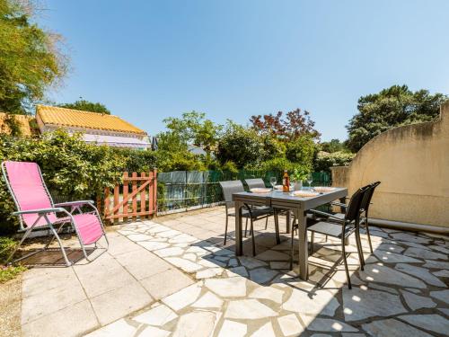 a patio with a table and chairs on a patio at Holiday Home Les Maisons de l'Océan-3 by Interhome in La Palmyre