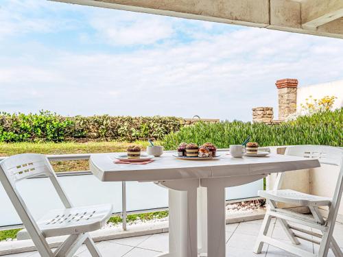 - une table et des chaises blanches sur la terrasse avec vue dans l'établissement Studio Penduick-2 by Interhome, à Quiberon