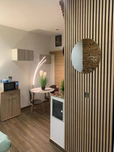 - une cuisine avec une table et un miroir mural dans l'établissement Studio 25m2 en plein cœur de Perpignan, à Perpignan
