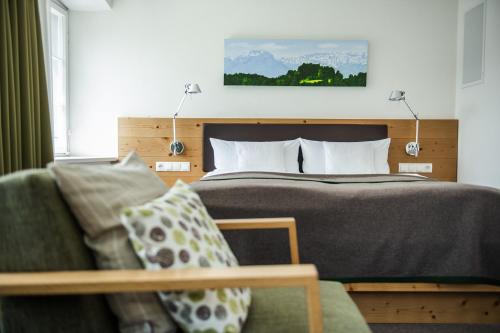 a hotel room with a bed and a couch at Hofgut Farny in Kißlegg
