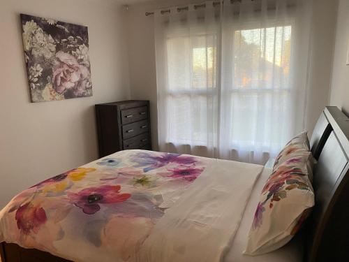 a bedroom with a bed with a flower pattern on it at Beautiful 3 Bedrooms BNB between Airport and Sea in Cheltenham