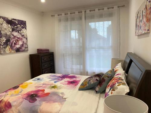 a bedroom with a bed with a flower pattern on it at Beautiful 3 Bedrooms BNB between Airport and Sea in Cheltenham