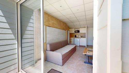 un salon avec un canapé et une cuisine dans l'établissement Bleu Horizon avec terrasse, à Bretignolles-sur-Mer