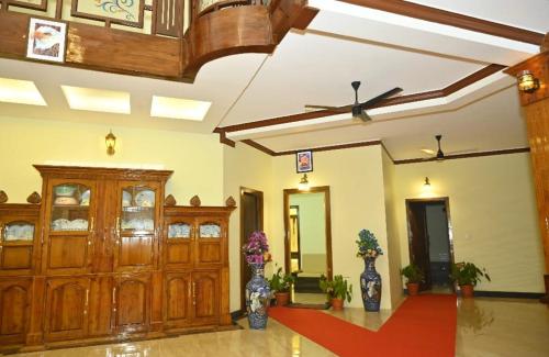 a large room with wooden doors and vases at NAVARATHNA International resort in Sollebail