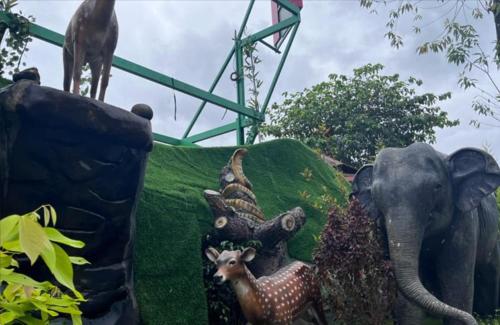 a display of figurines of animals and an elephant and a chicken at NAVARATHNA International resort in Sollebail