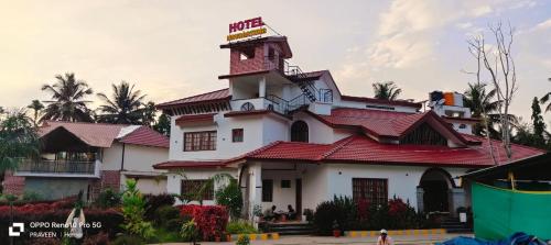 a large white building with a red roof at NAVARATHNA International resort in Sollebail