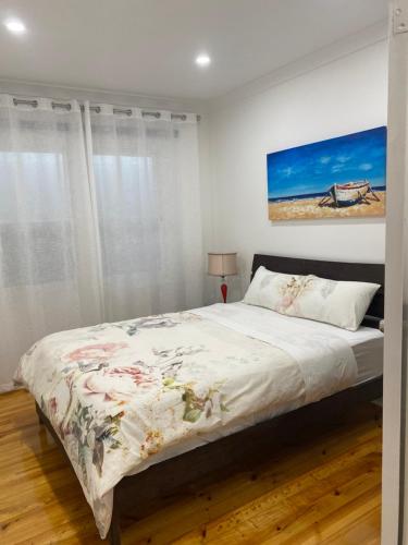 a bedroom with a bed and a painting on the wall at Beautiful 3 Bedrooms BNB between Airport and Sea in Cheltenham
