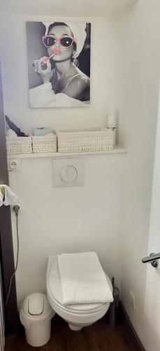 - une salle de bains avec des toilettes et une photo d'une femme dans l'établissement Le Belvédère-Cap Estérel-Var, à Saint-Raphaël