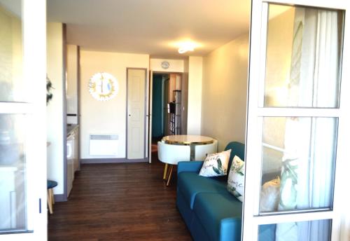 un salon avec un canapé bleu et une table dans l'établissement Le Belvédère-Cap Estérel-Var, à Saint-Raphaël