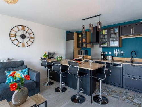 une cuisine avec des placards bleus et un bar avec des tabourets dans l'établissement Apartment L'Indigo by Interhome, à Pornic
