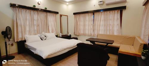 a bedroom with a white bed and a desk and window at NAVARATHNA International resort in Sollebail