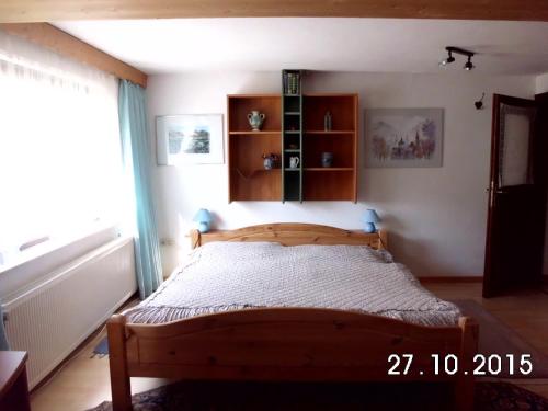 ein Schlafzimmer mit einem Holzbett in einem Zimmer mit einem Fenster in der Unterkunft Ferienwohnung an der Kyll in Birresborn
