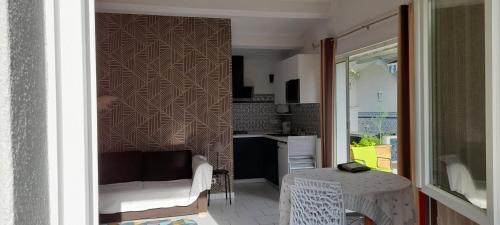 un salon avec une table et une cuisine dans l'établissement sur le Bassin d'Arcachon charmant studio de 28m2, à Gujan-Mestras