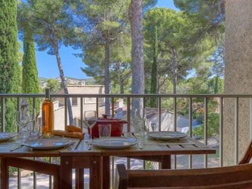 - une table en bois avec des verres à vin sur le balcon dans l'établissement Studio Les Hauts du Port-5 by Interhome, à Saint-Cyr-sur-Mer