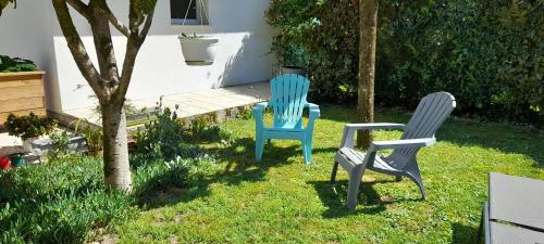 deux chaises assises dans l'herbe à côté d'un arbre dans l'établissement sur le Bassin d'Arcachon charmant studio de 28m2, à Gujan-Mestras