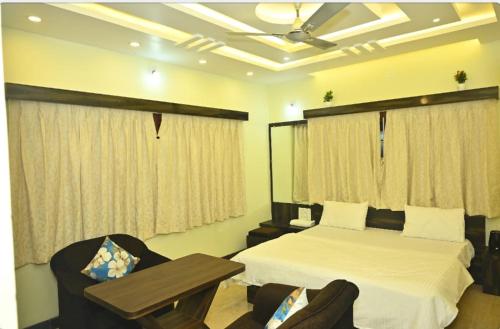 a bedroom with a bed and a table and chairs at NAVARATHNA International resort in Sollebail