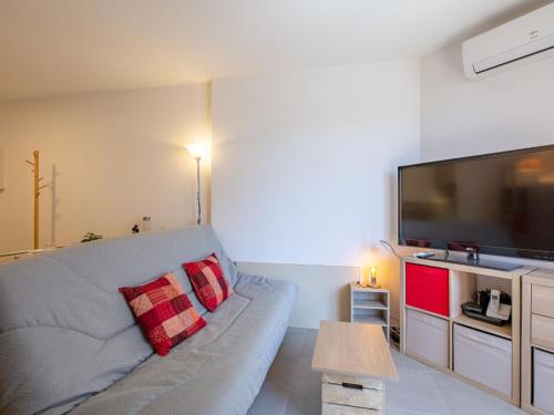 un salon avec un canapé et une grande télévision à écran plat dans l'établissement Studio Régina-15 by Interhome, à Sainte-Maxime