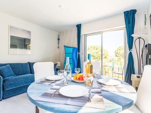 une salle à manger avec une table et un canapé bleu dans l'établissement Apartment Caesar Domus-8 by Interhome, à Saint-Tropez