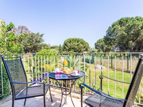 - une terrasse avec 2 chaises et une table avec un bol de fruits dans l'établissement Apartment Caesar Domus-8 by Interhome, à Saint-Tropez