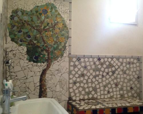 une salle de bain avec un arbre en mosaïque sur le mur dans l'établissement Appartement terrasse vue panoramique au coeur du Panier, à Marseille