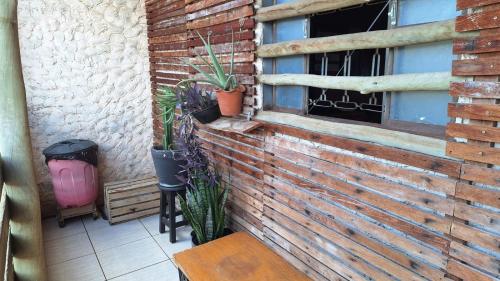 a brick wall with potted plants on a patio at Refrigerado Quarto sala cozinha e sacada in Cuiabá