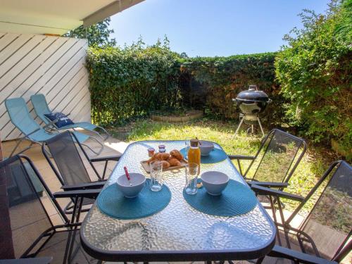 - une table et des chaises sur une terrasse avec barbecue dans l'établissement Apartment L'Orée du Golf-1 by Interhome, à Pornic