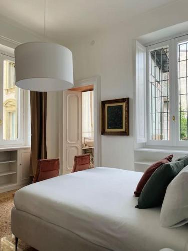 a bedroom with a large white bed and windows at L'Adagio in Gran Madre in Turin