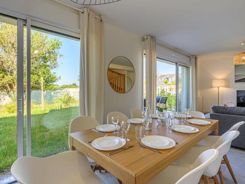 une salle à manger avec une table en bois et des chaises blanches dans l'établissement Holiday Home Les Salines by Interhome, à Carnac