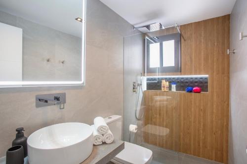 a bathroom with a white sink and a shower at Pueblo Evita Premium Suites in Benalmádena
