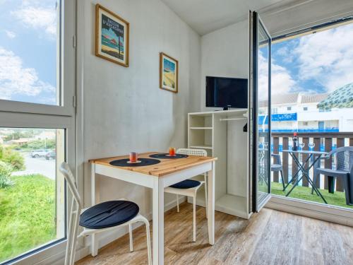 ein kleiner Raum mit einem Tisch und Stühlen und einem großen Fenster in der Unterkunft Studio Les Terrasses de l'Atlantique-8 by Interhome in Lacanau-Océan