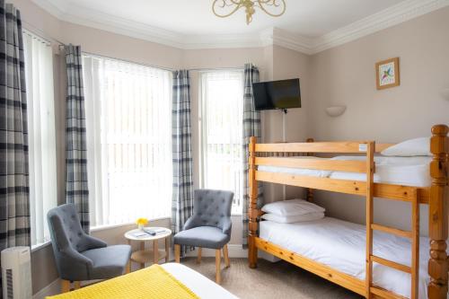 a bedroom with bunk beds and a desk and chair at The Courtyard Guest House in Great Yarmouth