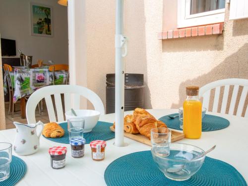 - une table avec une assiette de croissants et de jus d'orange dans l'établissement Holiday Home Le Moussaillon by Interhome, à Pornic