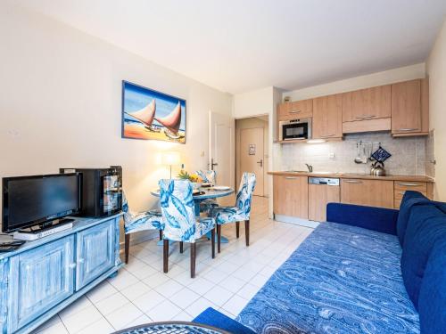 un salon avec un canapé bleu et une cuisine dans l'établissement Apartment Caesar Domus-5 by Interhome, à Saint-Tropez