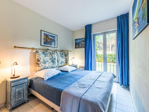 une chambre avec un lit bleu et une fenêtre dans l'établissement Apartment Caesar Domus-5 by Interhome, à Saint-Tropez