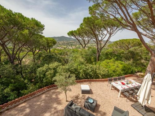 un patio avec une table, des chaises et des arbres dans l'établissement Holiday Home Riviera by Interhome, à Sainte-Maxime