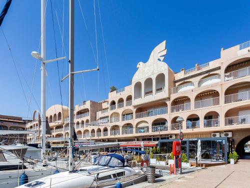 a large building with boats docked in front of it at Apartment Port de la Gavine I-3 by Interhome in Hyères