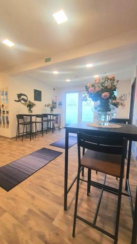 a room with tables and chairs with a vase of flowers at See Panzió in Fertőrákos