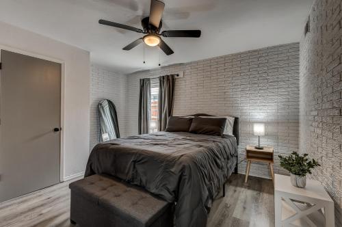 a bedroom with a ceiling fan and a brick wall at Lavish style 2BR in Stillwater with Free Parking and WiFi in Stillwater