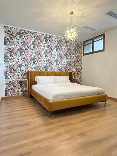 a bedroom with a bed with a floral accent wall at La casa di Ersilia in Cremia