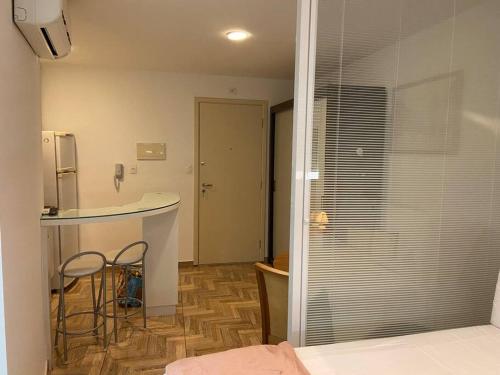 a kitchen with a counter and two chairs in a room at SH154 Descubra o Aconchego Próx Av Paulista in Sao Paulo