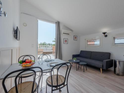 un salon avec une table, des chaises et un canapé dans l'établissement Apartment Pine's Mansion-2 by Interhome, au Barcarès